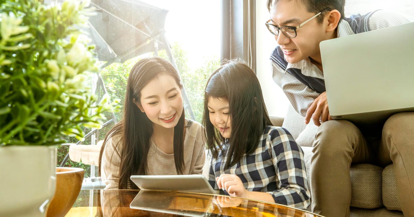 家族がリビングでタブレットを一緒に見ている様子